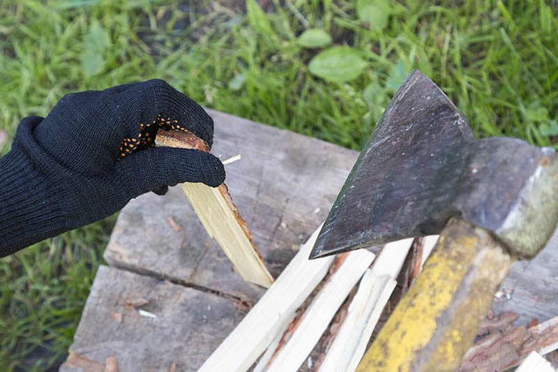 chopping-firewood-with-an-ax-to-make-pizza-splits Hand Cutting firewood